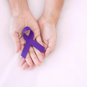 Two hands holding a purple ribbon for Domestic Violence Awareness Month