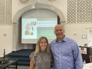Two staff members standing in front of the RentConnect presentation's opening slide.